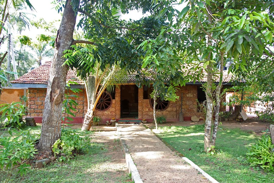 A laterite-walled Ayurveda treatment house under mango trees at Aluthgama