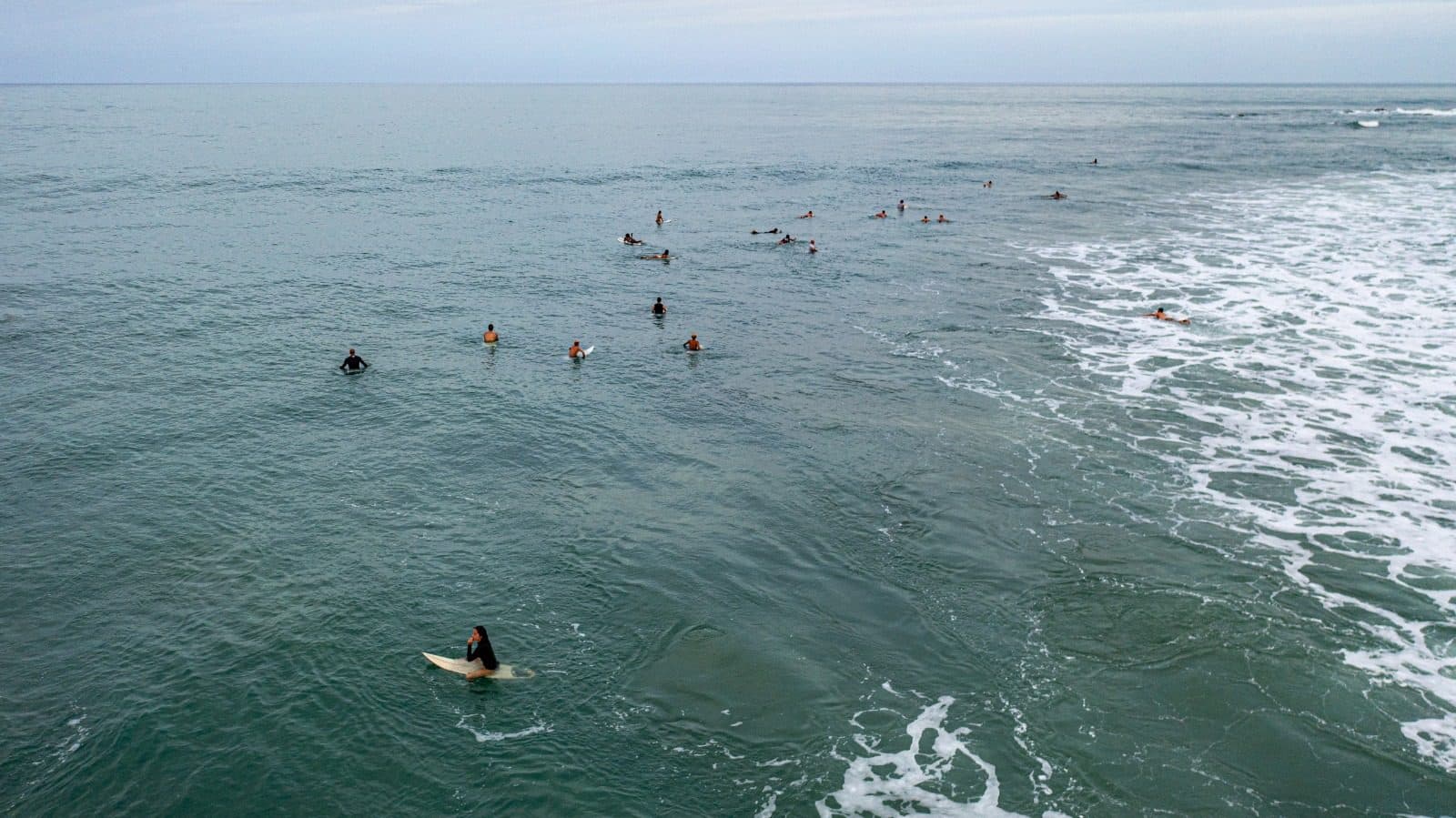 Surfers waiting in the line-up beyond the break